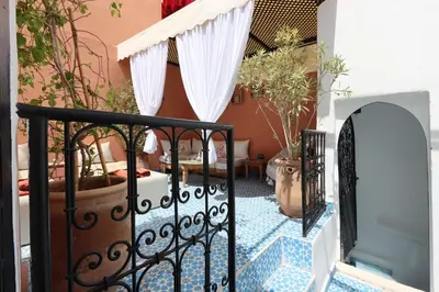 a balcony with a gate and potted plants at riad la girafe blanche de marrakech in Marrakech