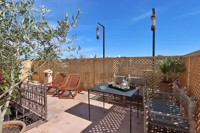 a patio with a table and chairs and a fence at Riad L'Hana, 3 ch, exclu medina in Marrakech