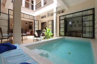 a swimming pool in a house with a bed and a room at Riad Lytes breakfast pool comfort private in Marrakech