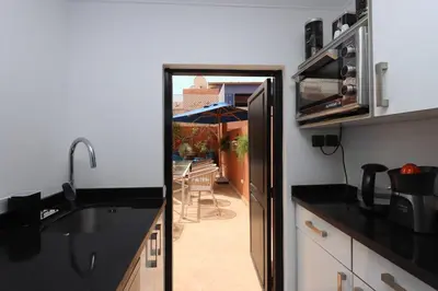 a kitchen with a view of a patio with an umbrella at Riad Lytes breakfast pool comfort private in Marrakech