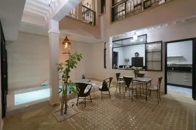 a living room with a table and chairs and a pool at Riad Lytes breakfast pool comfort private in Marrakech