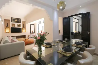 a dining room with a glass table and white chairs at Riad Lytes breakfast pool comfort private in Marrakech