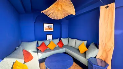 a blue room with a couch with colorful pillows at Riad Abi in Marrakech