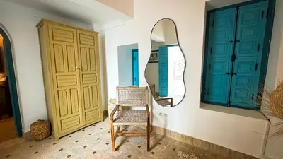 a dressing room with a chair and a mirror at Riad Abi in Marrakech
