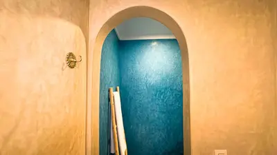a hallway with a blue wall and an archway at Riad Abi in Marrakech