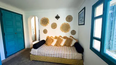 a bedroom with a bed with gold pillows on it at Riad Abi in Marrakech