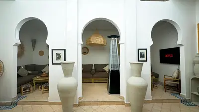 a living room with two white vases in a room at Riad Abi in Marrakech