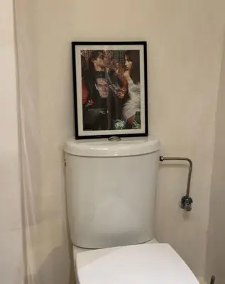 a picture on top of a toilet in a bathroom at Family apartement at Premium village in Marrakech