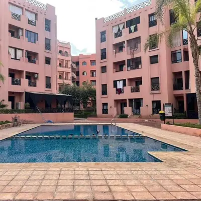 a swimming pool in front of two large buildings at Family apartement at Premium village in Marrakech