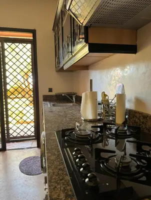 a kitchen with a stove top oven in a kitchen at Family apartement at Premium village in Marrakech