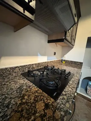 a black stove top oven in a kitchen at Élégance Apartment with 5 swimming pool for family in Marrakech