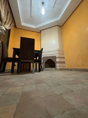 a dining room with a table and a fireplace at Élégance Apartment with 5 swimming pool for family in Marrakech