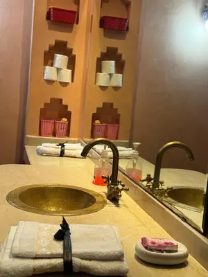 a bathroom with a sink and two faucets at Élégance Apartment with 5 swimming pool for family in Marrakech