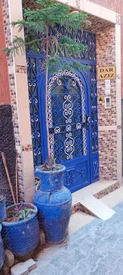 a large blue vase sitting in front of a door at Dar Kouzzou in Marrakech