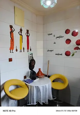 a room with a table and two yellow chairs at La nuit est bonne in Marrakech
