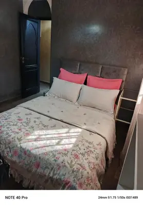a bedroom with a large bed with red pillows at La nuit est bonne in Marrakech