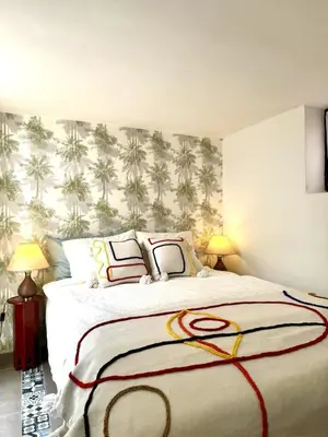 a bedroom with a large bed with palm trees wallpaper at Riad Nabil with Concierge and FREE Breakfast in Marrakech