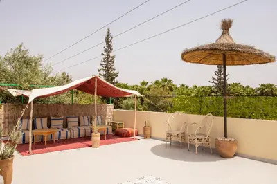 a patio with chairs and umbrellas on a fence at the old house in Marrakech