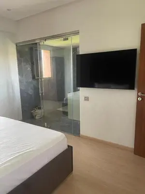 a bedroom with a bed and a large tv on a wall at Oasis des Lumières in Marrakech