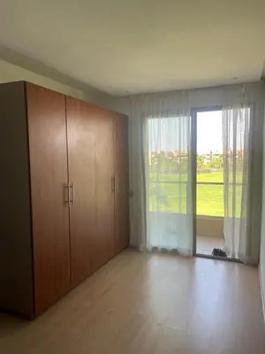 an empty room with a large window and wooden cabinets at Oasis des Lumières in Marrakech