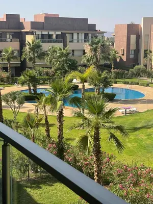 a view of a resort with palm trees and a pool at Oasis des Lumières in Marrakech
