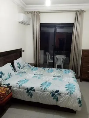 a bedroom with a bed with a blue and white comforter at Studio Au Centre Ville Marrakech in Marrakech