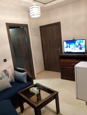 a living room with a blue couch and a tv at Studio Au Centre Ville Marrakech in Marrakech