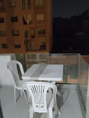 a white table and two white chairs on a balcony at Studio Au Centre Ville Marrakech in Marrakech