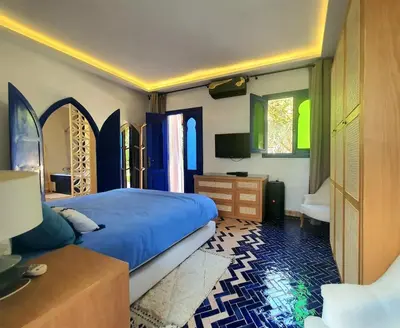 a bedroom with a bed and a dresser and windows at Family villa pool sauna and hammam in Marrakech