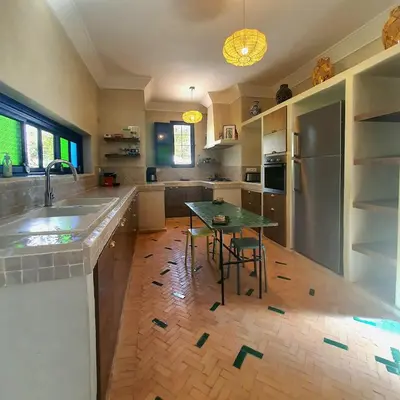 a kitchen with a table and a counter top at Family villa pool sauna and hammam in Marrakech