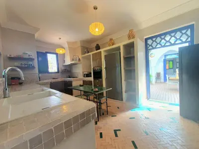 a kitchen with a sink and a table in it at Family villa pool sauna and hammam in Marrakech