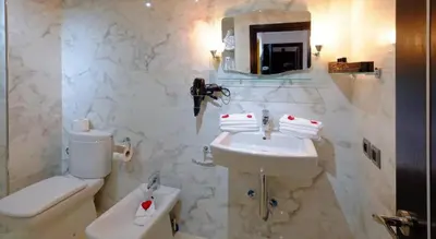 a white bathroom with a sink and a toilet at Marrakxi in Marrakech