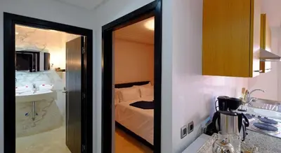 a room with a bedroom with a bed and a kitchen at Marrakxi in Marrakech