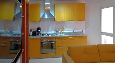 a kitchen with yellow cabinets and a couch in a room at Marrakxi in Marrakech