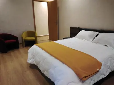 a bedroom with a large bed with a yellow blanket on it at Akenza hospitality in Marrakech