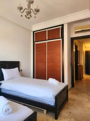 a bedroom with two beds and a large window at MARRAKECH CENTRE Appartement in Marrakech