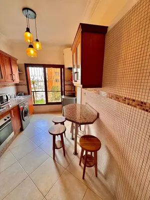 a kitchen with a table and two stools at MARRAKECH CENTRE Appartement in Marrakech