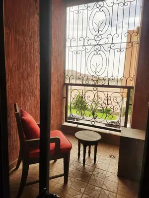 a chair and a table in front of a window at MARRAKECH CENTRE Appartement in Marrakech