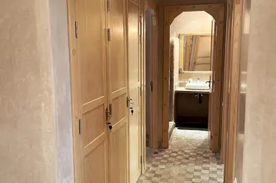 a bathroom with a door leading to a sink at Atlas Gardens Apartment in Sraghna