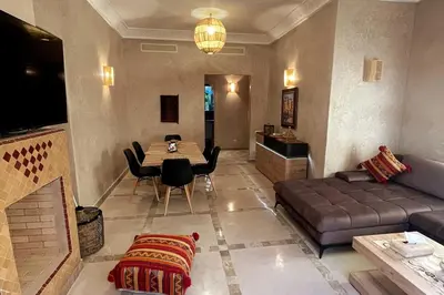 a living room with a couch and a table at Atlas Gardens Apartment in Sraghna