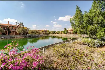 a pond in a park with pink flowers at Prestige authentique in Marrakech