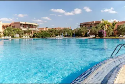 a large pool with blue water in a resort at Prestige authentique in Marrakech