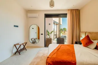 a bedroom with a large bed and a mirror at Luxury 5-Star Villa - Games & Activities - 15 min to Center in Marrakech