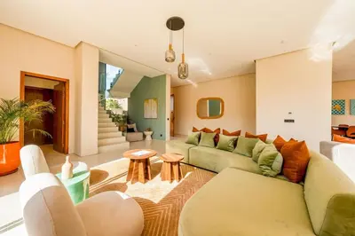 a living room with a green couch and tables at Luxury 5-Star Villa - Games & Activities - 15 min to Center in Marrakech