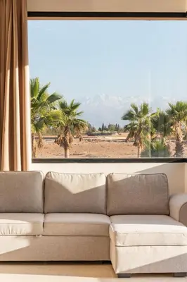 a living room with a couch in front of a window at Luxury 5-Star Villa - Games & Activities - 15 min to Center in Marrakech