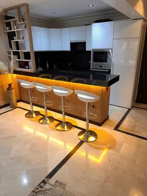 a kitchen with four bar stools in front of a counter at Duplex Sur Marrakech Guéliz in Marrakech