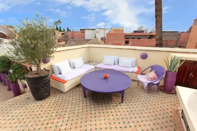 a patio with a table and chairs on a roof at Dar Charkia in Marrakech