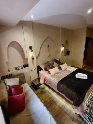 a bedroom with a large bed and a couch at Authentic Apartment Riad Style in Gueliz for Family in Marrakech