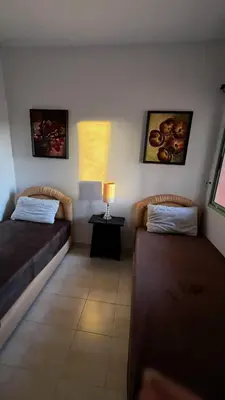 two beds in a room with a lamp on a table at Bright with great view in Marrakech