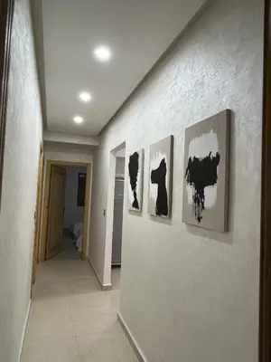 a hallway with three paintings on a wall at Modern Apartment with Fully Equipped Kitchen Perfect Location in Marrakech in Marrakech